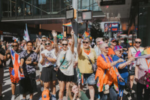 A group of people hold pride flags in the parade.