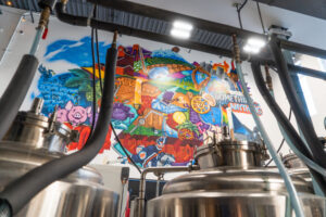 A colourful mural behind some brewing equipment at Arcadia