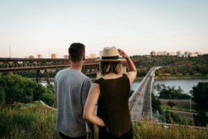 Couple looks out at river valley.