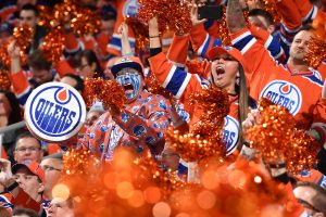 The crowd cheers at an Edmonton Oilers hockey game.