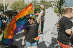 A photo of someone posing with a pride flag.