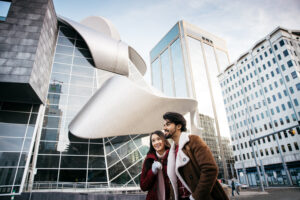 A couple takes a walk in front of the Art Gallery of Alberta.