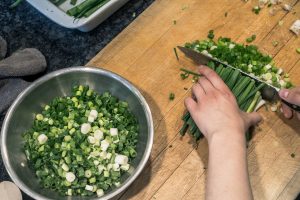 Edmonton's green onion cake man, chops green onions in preparation for green onion cakes
