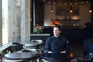 Chef sits at table in restaurant