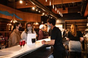 People order drinks at the counter of 5th Street Food Hall.