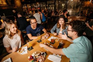 A group of friends drinking beer and eating snack at Situation Brewery.