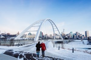 A couple walking up to the Walterdale Bridge in winter.
