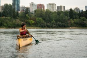 Man canoes on the North Saskatchewn River in amiskwacîwâskahikan.