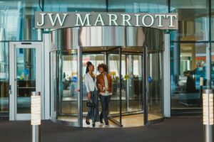 A couple exits through the revolving door of the JW Marriott.