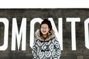 Linda Hoang stands in front of an Edmonton sign.