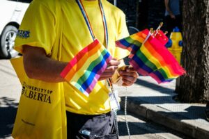 A person holds pride flags.