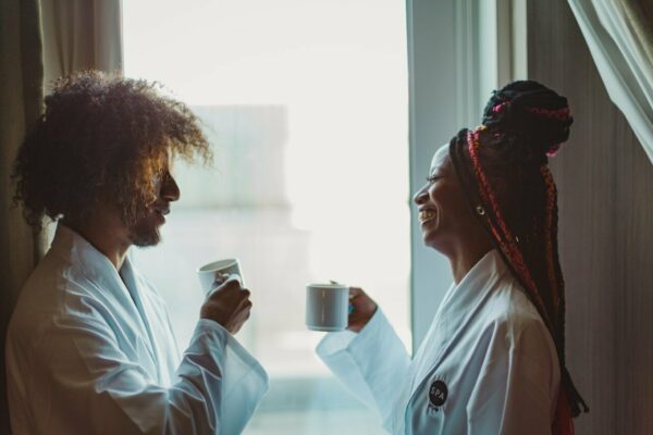 A man and a woman sip out of coffee mugs at the JW Marriott