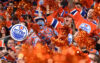 Fans in orange jerseys cheer at an Edmonton Oilers game.