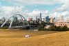 Two girls are seen sitting on Walterale hill overlooking the Walterdale Bridge in the summer time.