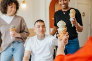 Three people hold ice cream cones.