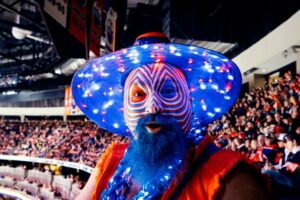 A fan dressed up in dazzling orange and blue attire at an Edmonton Oilers game in Rogers Place.