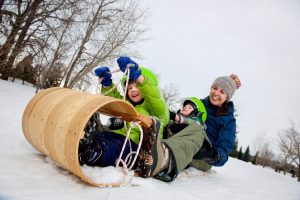 A family of three sleds down a hill in Edmonton.