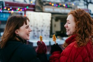 Two people enjoy frozen maple syrup.