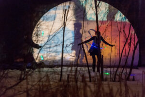 A performer in front of a lit backdrop at the Silver Skate Festival.