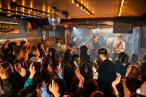 A crowd dances to a live band on stage.