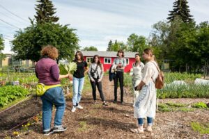 A group standing with a guide at the Edmonton Urban Farm.