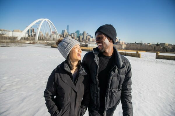 Two people smiling in front of the Walterdale Bridge.